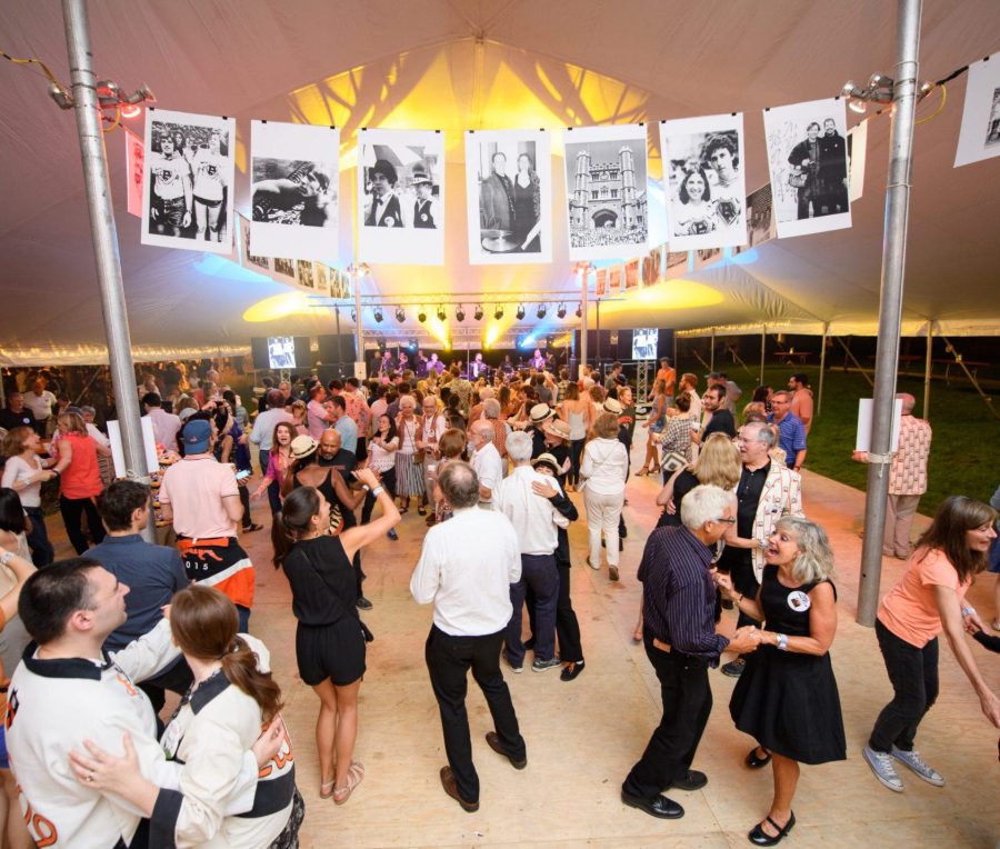 Guests dancing under a marquee hung with black and white photographs